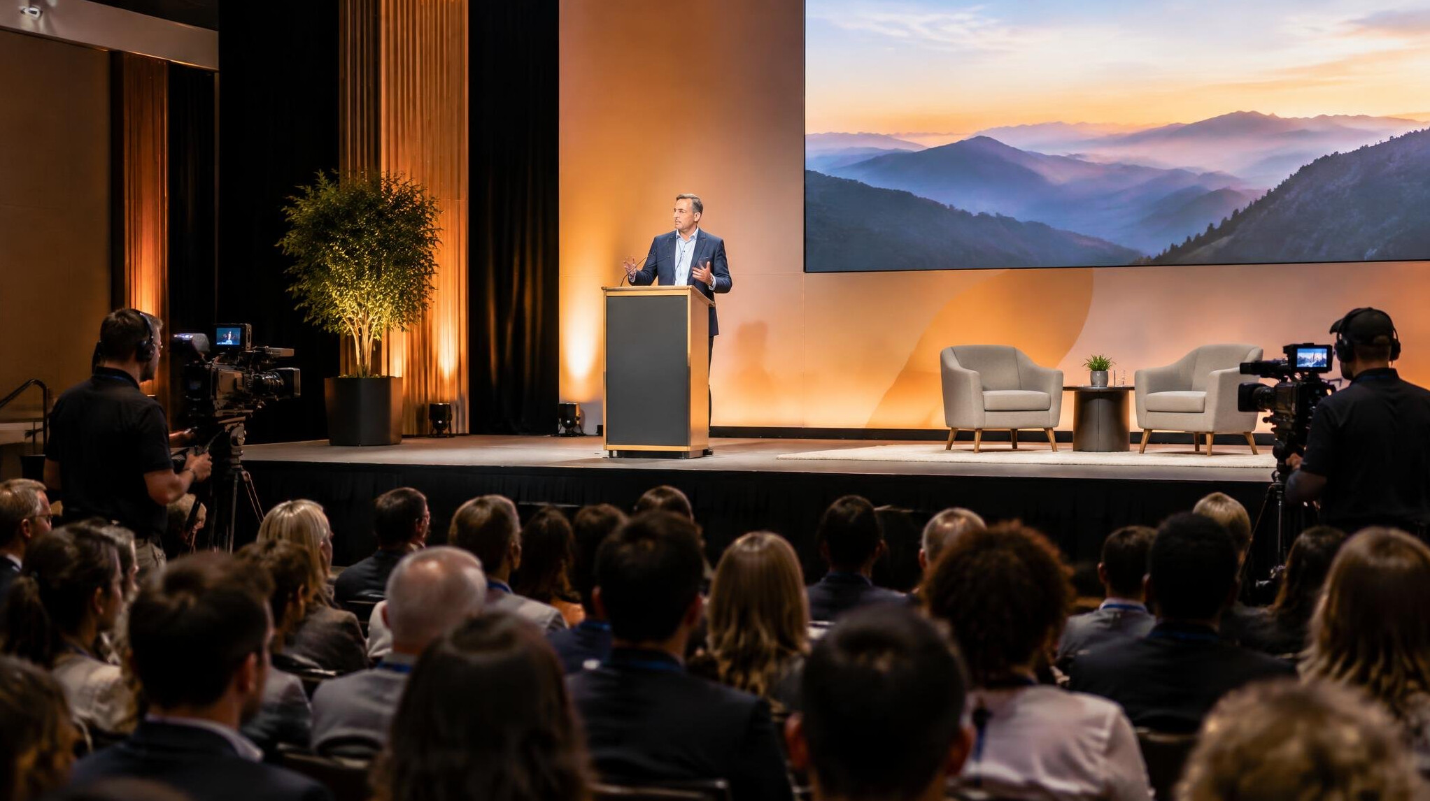 Event stage with speaker and audience under stage lighting